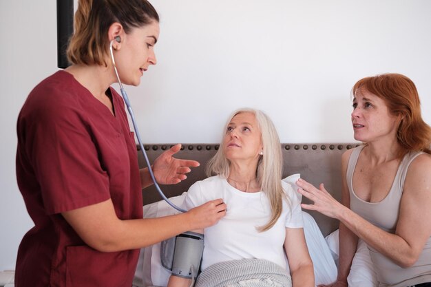 Doctor attending home to a patient in bed taking her blood pressure Concept health care medicine emergencies