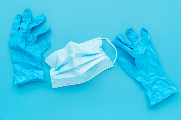 Doctor blue gloves and mask on blue background, stay home help doctor to prevent covid-19 spread campaign