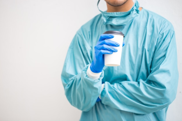 Doctor in blue scrubs relaxing with coffee break.