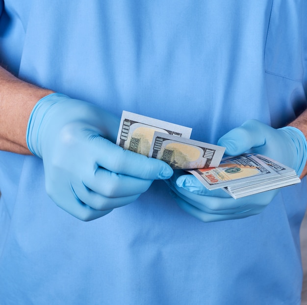 Doctor in blue uniform and gloves recounts money