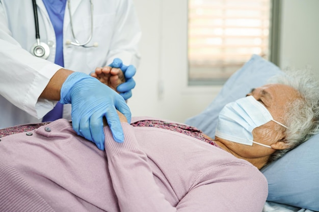 Doctor check Asian elder senior woman patient wearing a mask for protect covid coronavirus