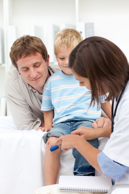 A doctor checking little boy's reflex