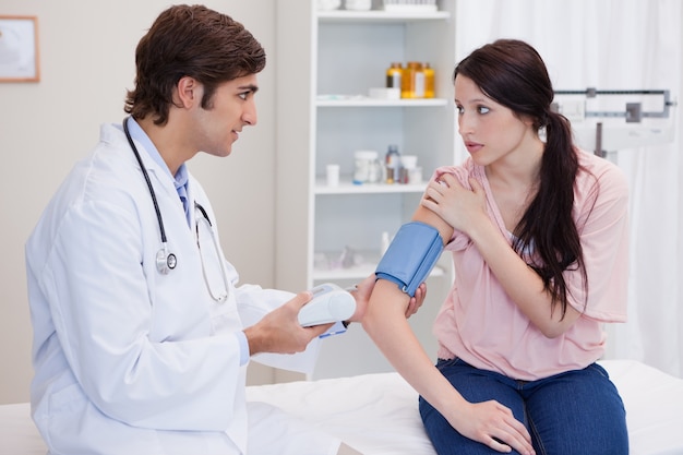 Doctor checking patients blood pressure