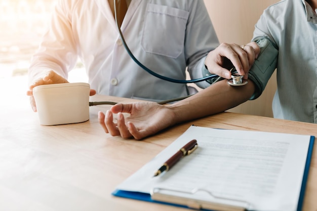 Doctor checking a senior patients blood pressure in office room