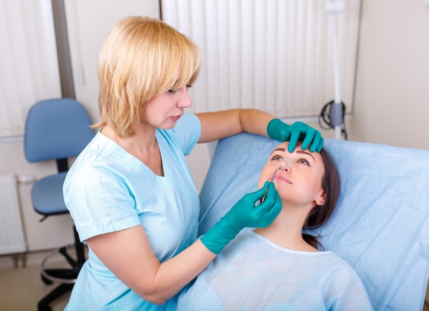 Doctor checking woman's face, the eyelid before plastic surgery, blepharoplasty. 