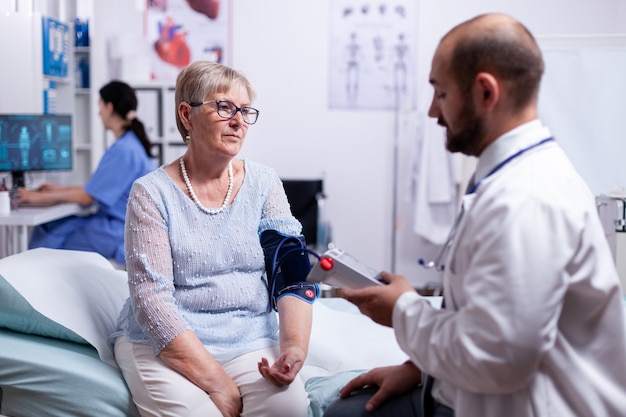 Doctor checking woman tension using portable arm digital preassure to check blood flow