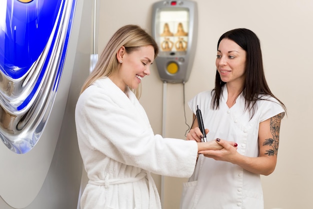 Doctor checks the tanning level on the skin of the girl Beautician is talking to a girl in the spa