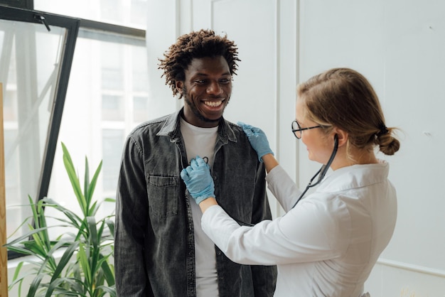 A doctor checks a young man's chest.