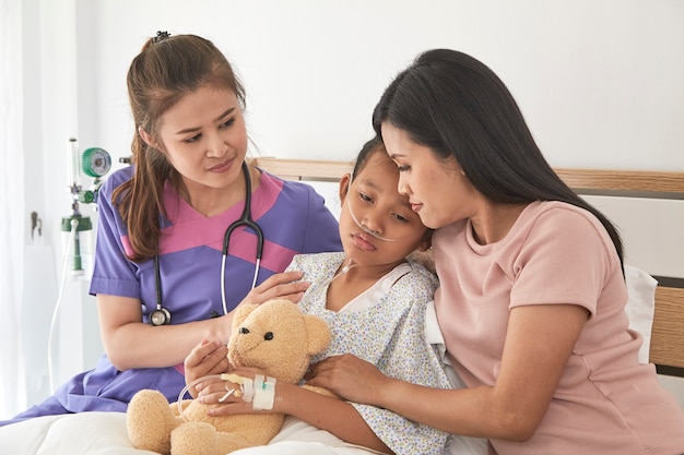 Doctor and child with mother in hospital