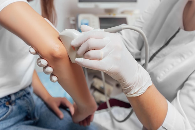 Doctor conducting ultrasound examination of patients elbow in clinic