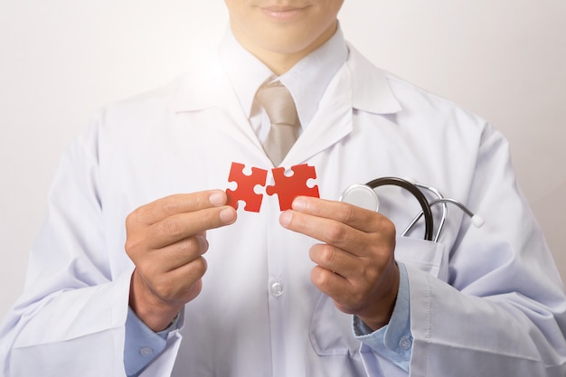 Doctor connecting jigsaw pieces of a head