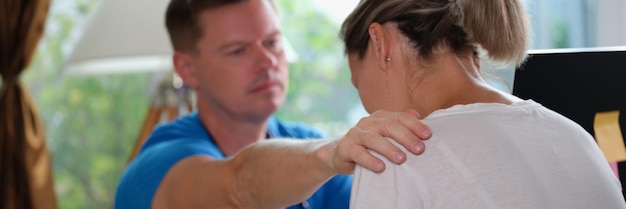 Doctor consoles patient with dangerous diagnosis at his desk in clinic male doctor put his hand