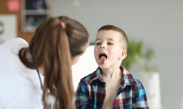 Doctor consults little boy with sore throat