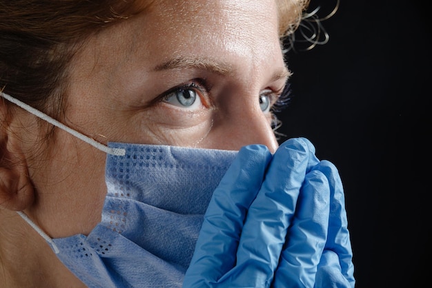 The doctor cries tears streaming down his face a female in a mask and gloves face closeup the doctor