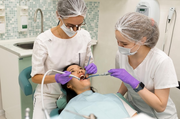 Doctor dentist doing medical stomatology examination for woman patient using professional tools