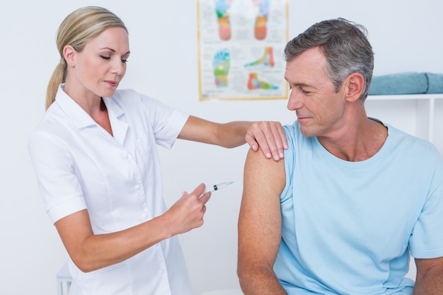 Doctor doing an injection to her patient 