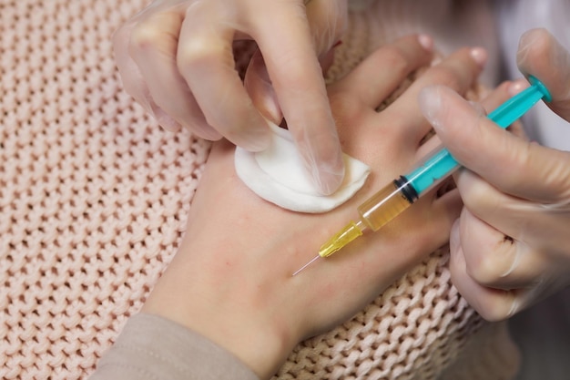 Doctor doing stem cell therapy on a patient's elbow after the injury Treating knee pain with plateletrich plasma injection Treatment of arthritis and osteoarthritisMedical and cosmetology concept