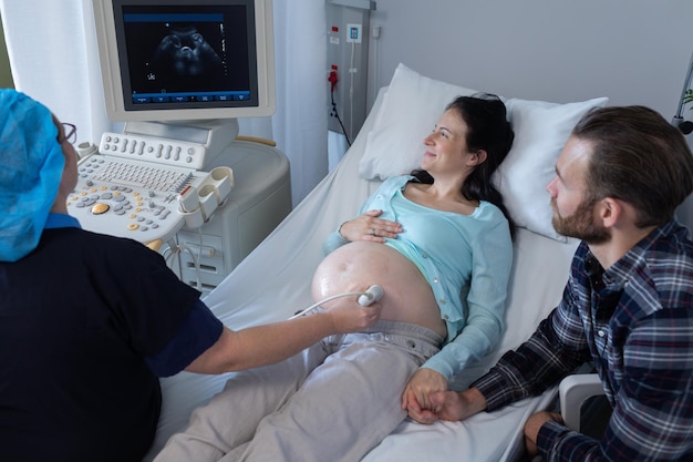 Doctor doing ultrasound scan for pregnant woman in hospital