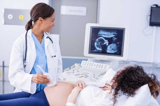 Doctor doing ultrasound scan for pregnant woman