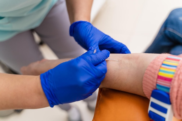 Doctor drawing blood sample from arm for blood test. Selective focus.