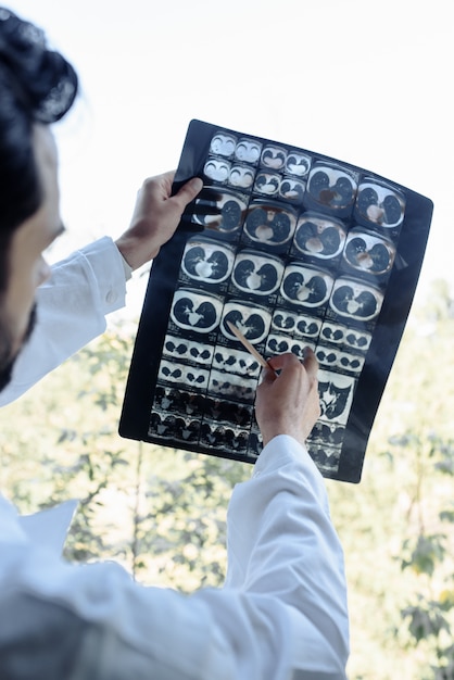 Doctor examines an x-ray on a white