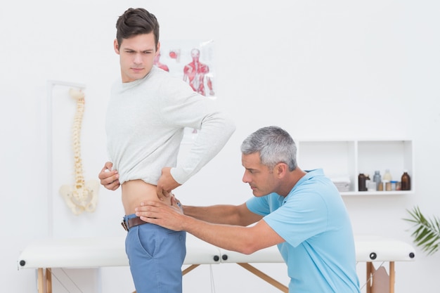 Doctor examining his patient back in medical office 