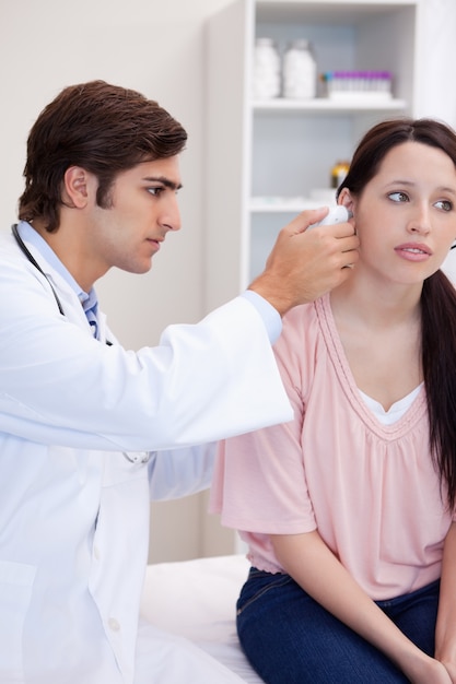 Doctor examining his patients ear