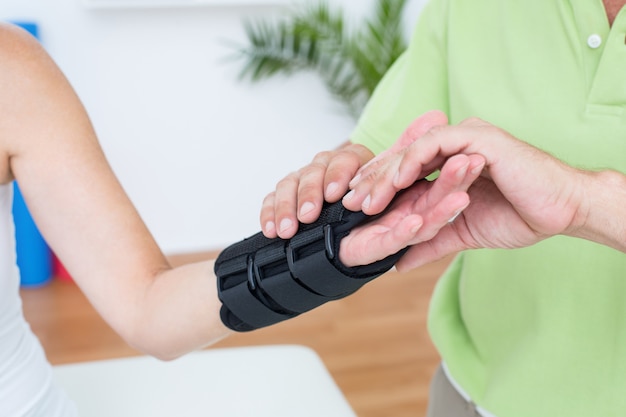 Doctor examining his patients wrist