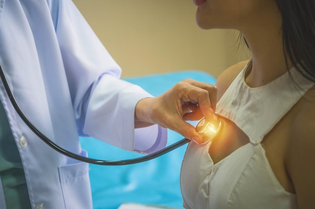 Doctor examining patient lungs using stethoscope at hospital and clinic