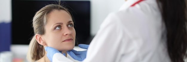 Doctor examining patients submandibular lymph nodes in clinic