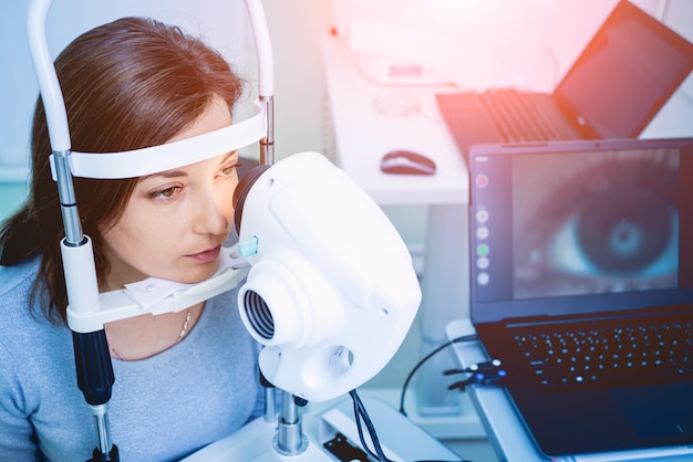 Doctor examining woman's eyes with a measurement machine.