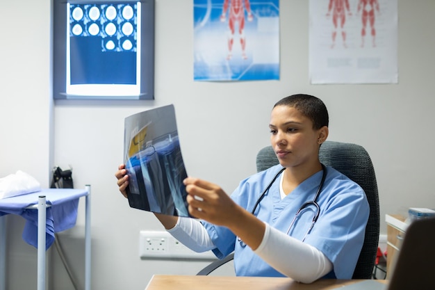 Doctor examining xray report at desk in hospital