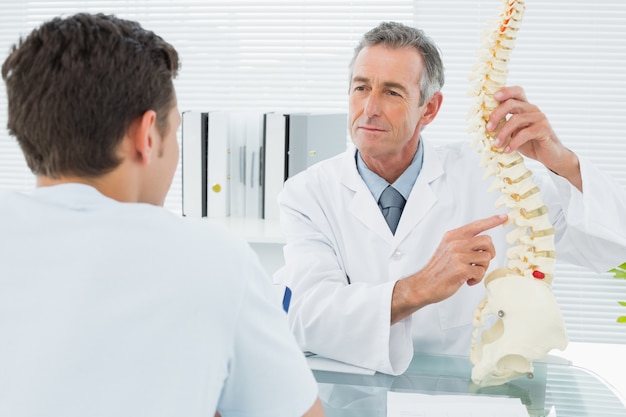 Doctor explaining spine to a patient in office