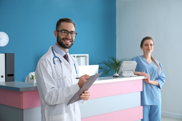 Doctor and female receptionist near desk in clinic