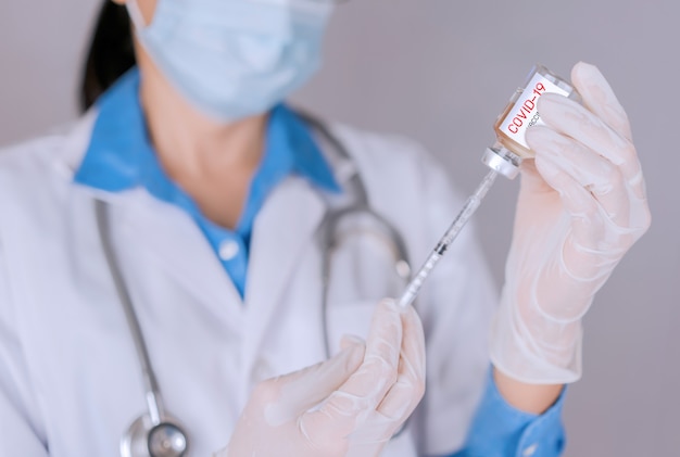 Doctor filling syringe for treat Covid 19 and cure and protect