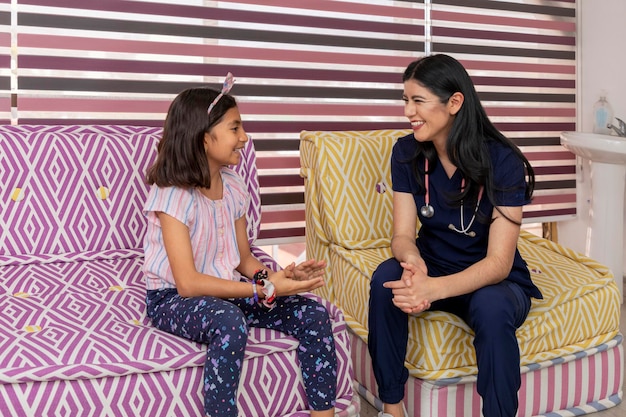 A doctor and a girl chatting on a chair in a paediatric doctor's office