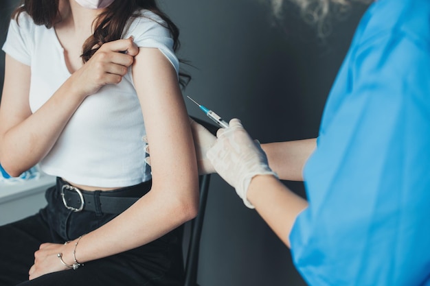 Doctor giving a patient injection subcutaneous in arm virus protection professional medical concept