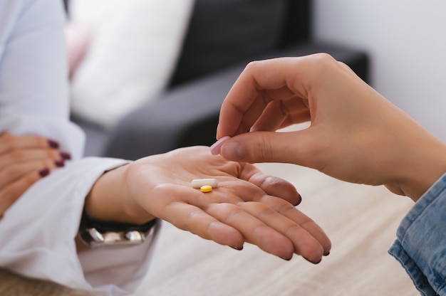 Doctor giving pills to a patient