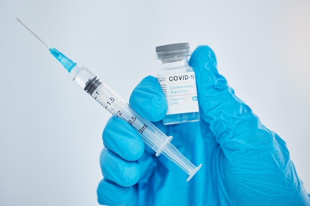 Doctor hand and covid vaccine syringe and medicine for health safety and protection from virus against mockup space background Medical expert glove and covid 19 treatment for pandemic healthcare