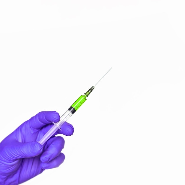 Doctor hand hold syringe in purple glove Injection yellow vaccine concept Medical injector for science test Close up health care vaccination Therapy drug surgery banner with copyspace