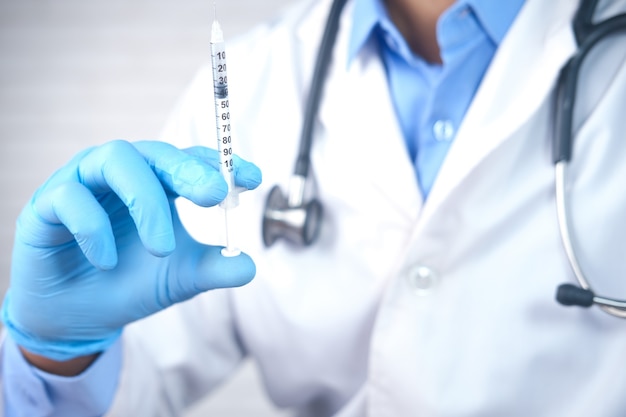 Doctor hand in medical gloves holding syringe