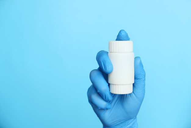 doctor hand in protective glass holding pill container