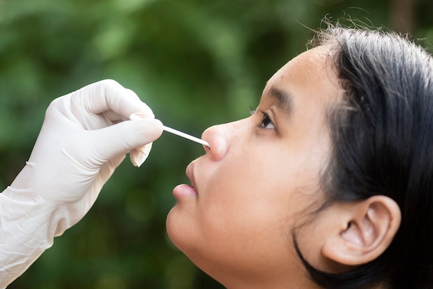 Doctor hand   taking a nasal swab from a person to test for possible coronavirus infection. Nasal mucus testing for viral infections