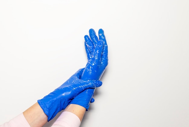 Doctor hands in gloves with stethoscope, medical exam concept over white background.