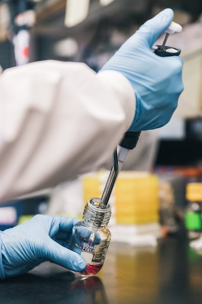 Doctor hands inserting liquid into flask