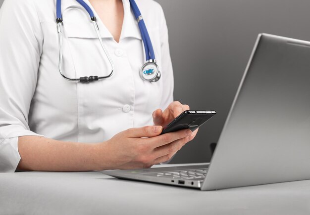 Doctor hands using mobile phone laptop computer information technologies consulting online