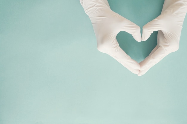 Doctor hands with gloves making heart shape, donation, world heart day concept