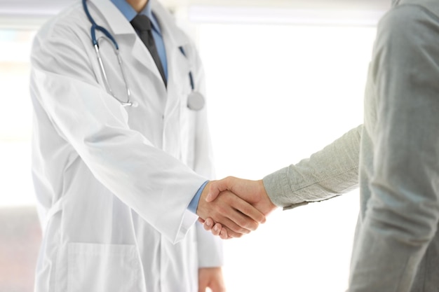 Doctor handshaking with patient in hospital