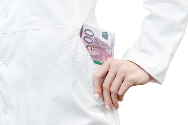 doctor has put a pack of euro money in his pocket, close-up, isolated on white background