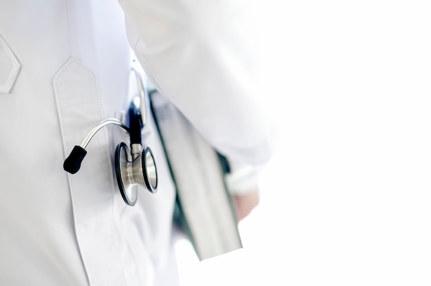 Doctor holding book with stethoscope in coats pocket